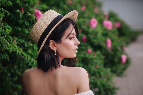 Outdoor close up portrait of young beautiful happy smiling girl wearing stylish straw hat.