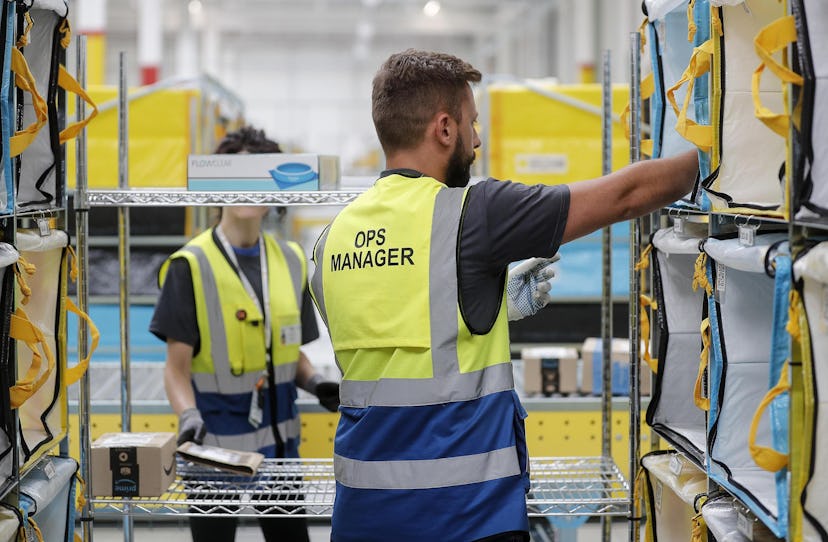 Workers sort packages in the new Amazon Sorting Warehouse in the Settecamini area of Rome, 11 July 2...