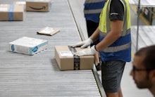 Workers sort packages in the new Amazon Sorting Warehouse in the Settecamini area of Rome, 11 July 2...