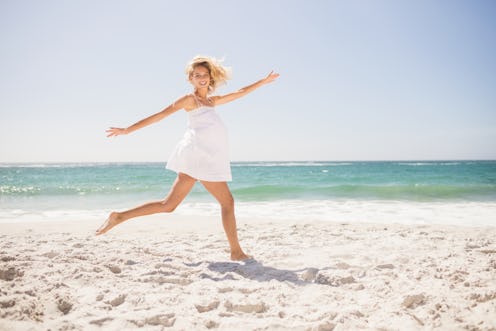 Pretty blonde woman jumping on the beach