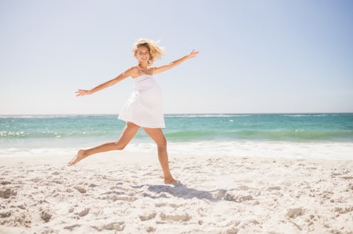 Pretty blonde woman jumping on the beach