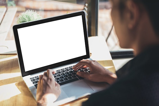 Young man working on his laptop with blank copy space screen for your advertising text message in of...