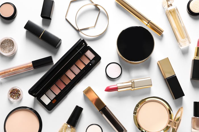 Different luxury makeup products on white background, top view