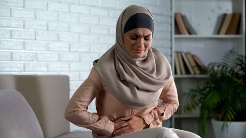 Muslim woman suffering abdominal pain, period cramp, needs medical aid