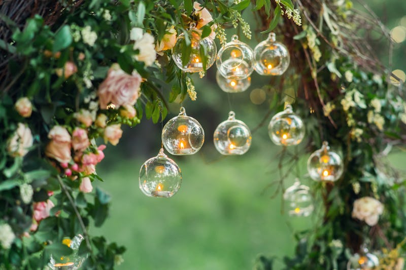 Wedding decor, candles in glass flasks in the forest.