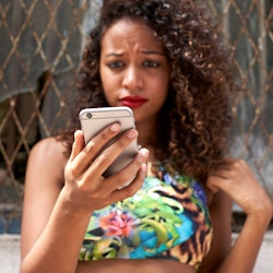 Woman frowning checking her phone                          