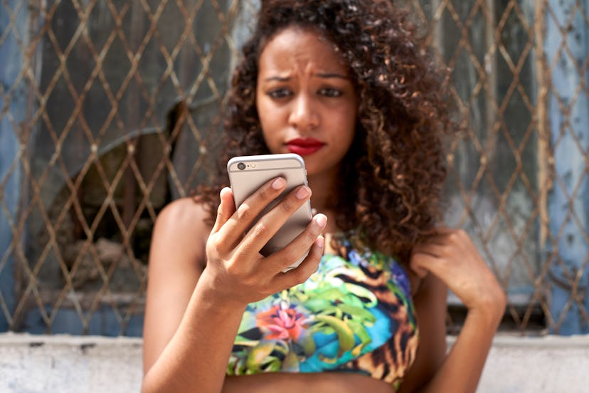 Woman frowning checking her phone                          