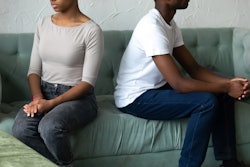 Crop close up of african American husband and wife sit separately back to back on couch avoid talkin...