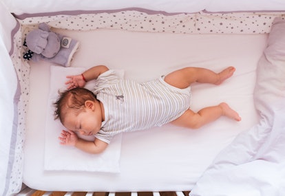 Top view of newborn baby sleeping in crib