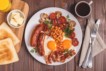 Traditional full English breakfast with fried eggs, sausages, beans, mushrooms, grilled tomatoes and...