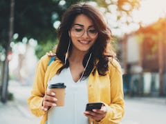 Lifestyle portrait of happy woman walking in the city on a sunny summer day, beautiful young girl dr...