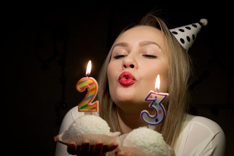 Girl birthday blows out the candles on the cake in the dark