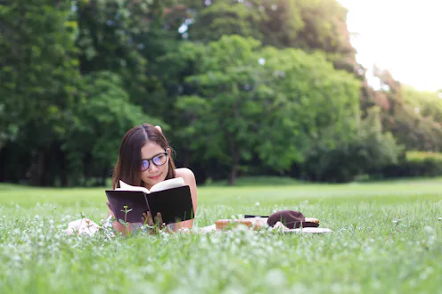 Young woman reading a book in the park