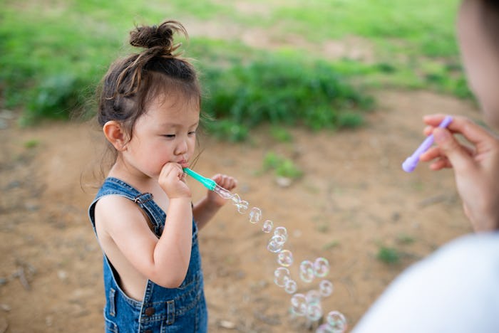 Mother and daughter playing with soap bubbles