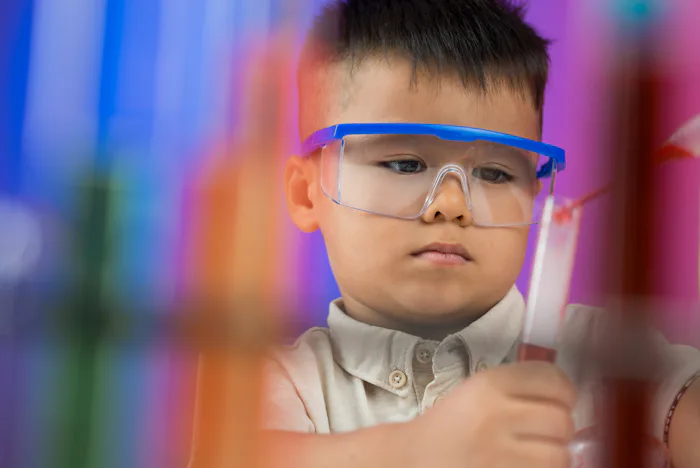 Blurred image of a young researcher dropping in the test-tube on the foreground