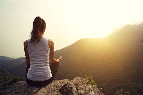 young yoga woman at spring mountain peak