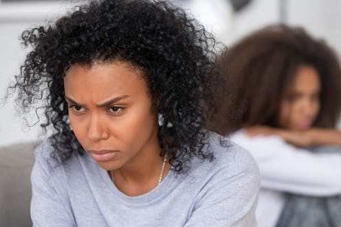 Upset angry African American mother ignoring teen daughter after quarrel, stubborn annoyed mum not t...