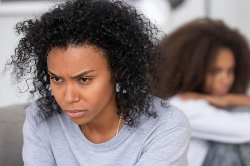 Upset angry African American mother ignoring teen daughter after quarrel, stubborn annoyed mum not t...