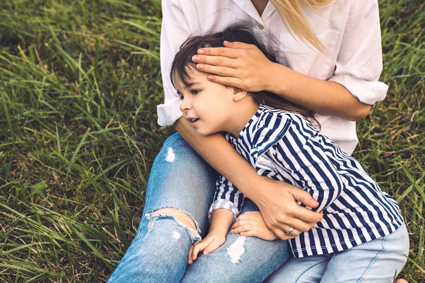 Cropped image of cute little girl embrace her mother outdoor. Loving mother and daughter lying on th...