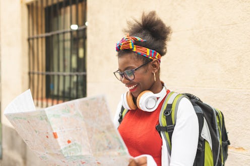 Afro American Girl Traveling Alone and Using a Map. Afro Teenager Girl Traveling Alone ,Wearing Head...