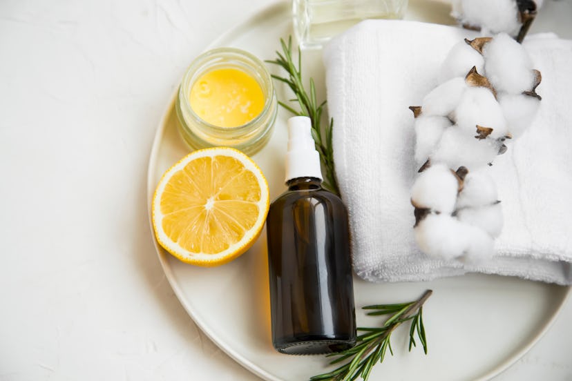 Natural organic spa ingredients with lemon, rosemary branches, balm jar, face mist spray bottle, cot...