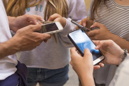 group of young people with mobile phones on the street