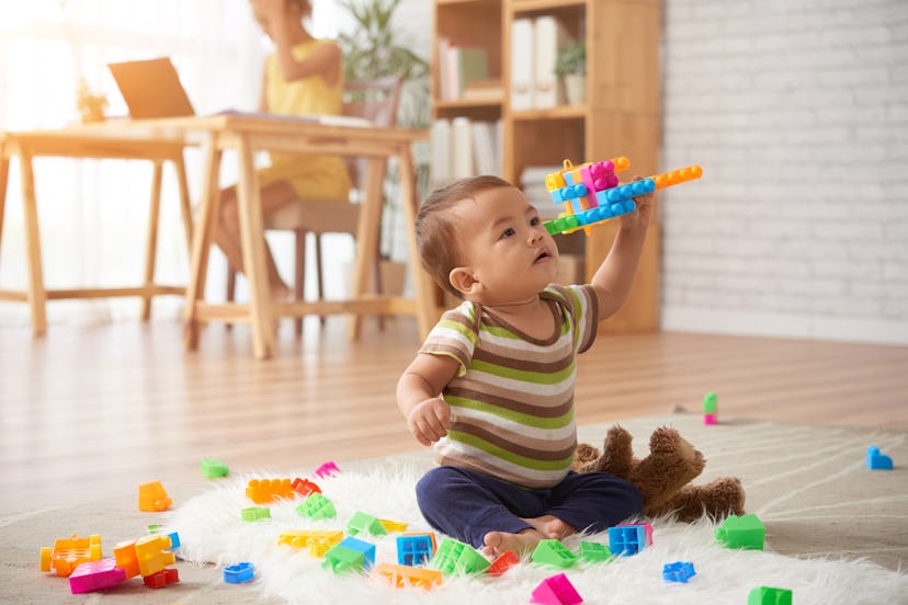 Vietnamese baby boy playing with plastic blocks