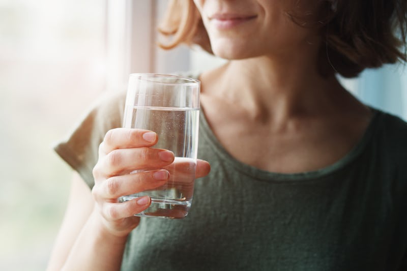 Young woman holding a glass of water