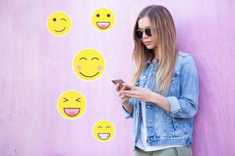 Cute Young Adult Girl Typing  on Smartphone With Variable Yellow Emoticons Sticker Communication Con...