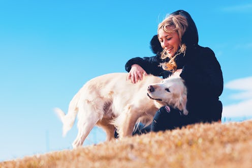 Pets and dogs.Blonde girl smiling and enjoying her pet dog in the park.