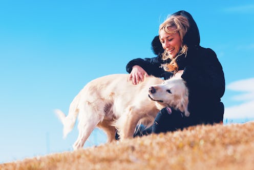 Pets and dogs.Blonde girl smiling and enjoying her pet dog in the park.