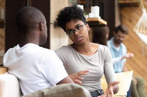 Focused African American woman talking with man in cafe, girlfriend discussing relationships with bo...