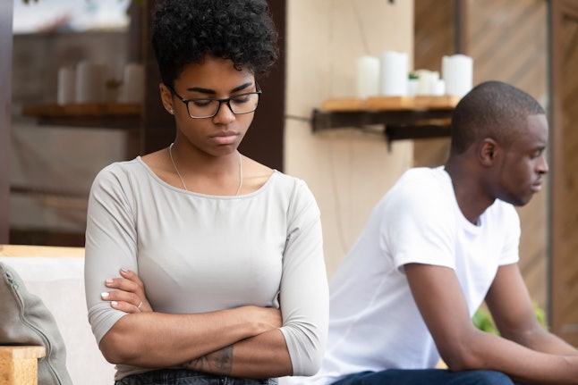 Stubborn african american couple angry after fight sit silent turn back, annoyed jealous upset girlfriend with arms crossed ignore sad unhappy boyfriend, problems in bad family relationship concept