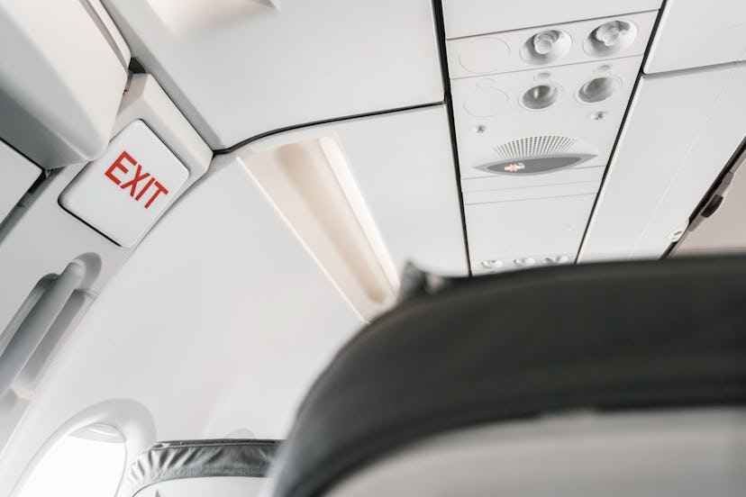 emergency exit sign on airplane. Empty airplane seats in the cabin. Modern Transportation concept. A...