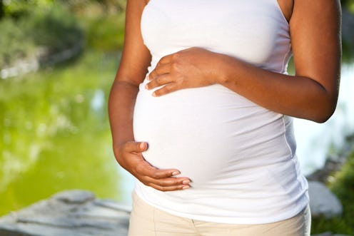 Pregnant woman holding her stomach.