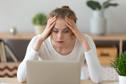 Stressed frustrated young woman student looking at laptop reading bad email internet news feeling sa...