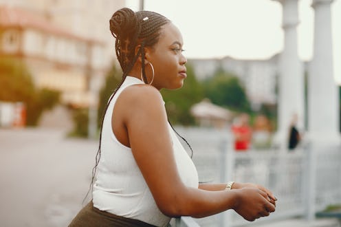 Stylish black girl in a park. Fashionable woman in a summer city. Lady in a white top.