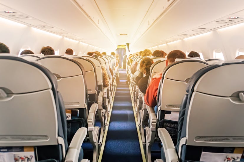 Commercial aircraft cabin with rows of seats down the aisle. morning light in the salon of the airli...