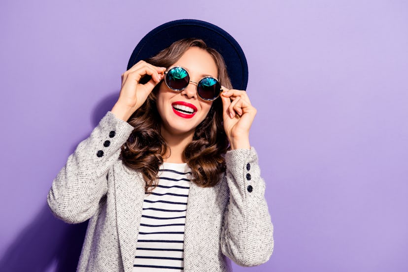 Portrait of funny carefree girl holding eyelets of glasses with two hands having rest relax isolated...