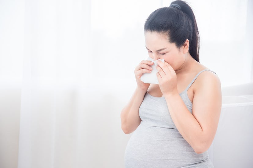 Pregnant woman wipe her nose by tissue paper. Pregnancy health and medicine concept. 