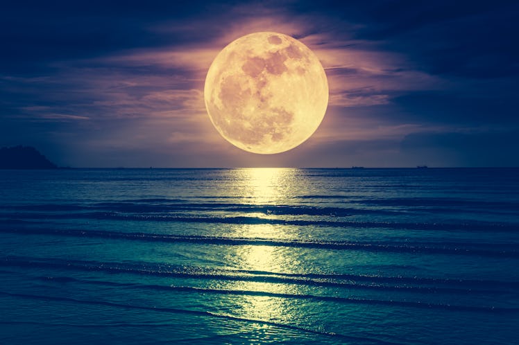 Super moon. Colorful sky with cloud and bright full moon over seascape in the evening. Serenity natu...