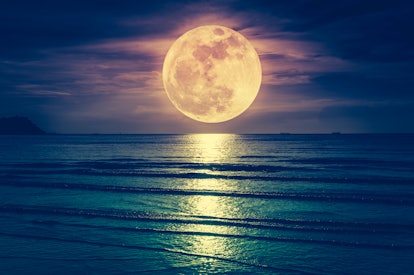 Super moon. Colorful sky with cloud and bright full moon over seascape in the evening. Serenity natu...