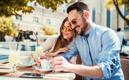 Flirting in a cafe. Beautiful loving couple sitting in a cafe drinking coffee and enjoying in conver...