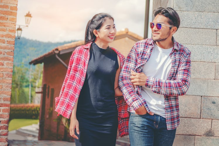 Happy young couple walking on the street in old town. Travel and dating concept.