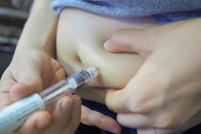 Woman use pre-filled pen syringe for take the FSH (Follicle Stimulating Hormone) to stimulate the ov...