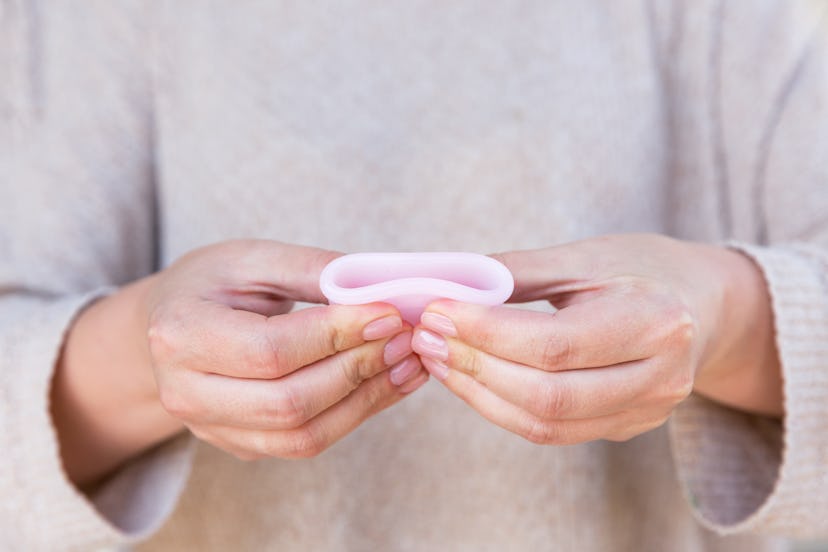 The menstrual cup is holding by woman hands. Selective focus.