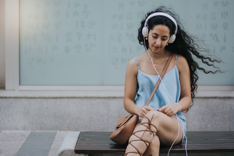 Woman listening to her headphones and texting.