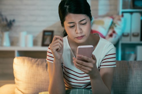 upset sad skeptical unhappy serious asian woman talking texting on phone displeased with conversatio...