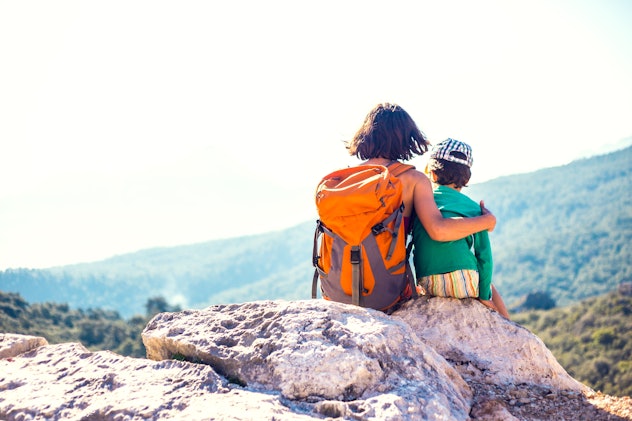 The boy and his mother are sitting on the top of the mountain. A woman travels with a child. Baby hu...