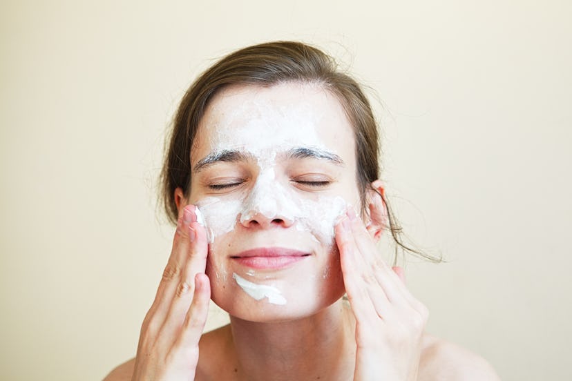 pretty young woman with clay mask on her face, facial care